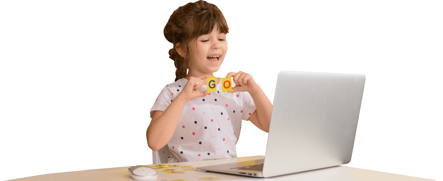 A child using letter cards beside a laptop.